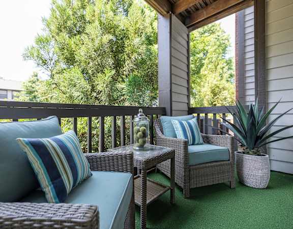 a covered porch with wicker furniture and a window