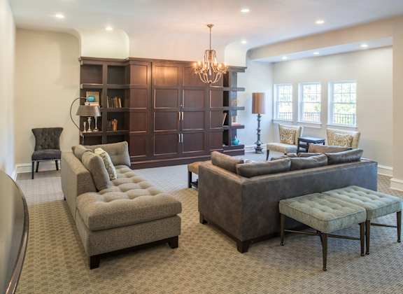 A living room with a grey couch and a brown bookcase