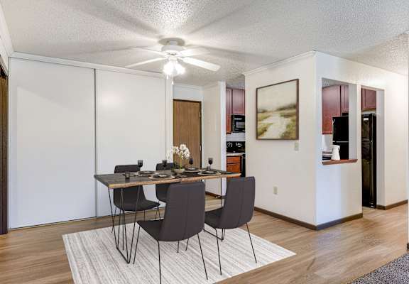 a dining room with a table and chairs and a ceiling fan