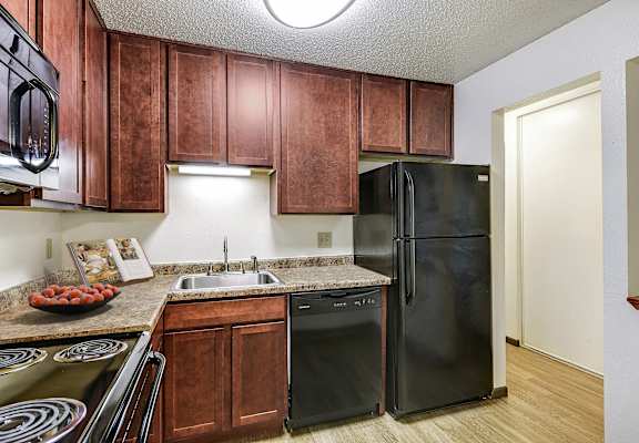 a kitchen with black appliances and wooden cabinets
