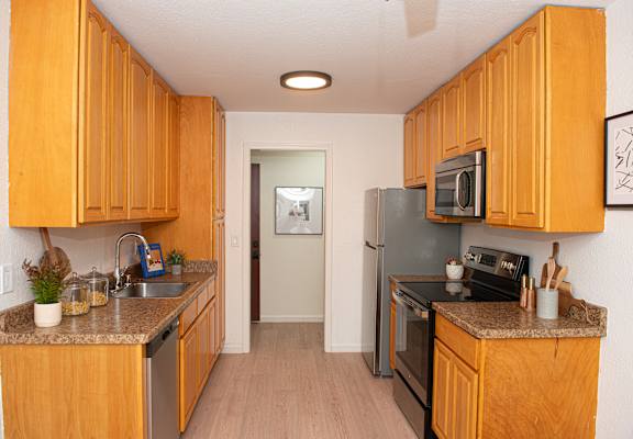 A kitchen with wooden cabinets and a black stove top oven.