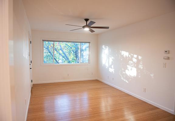A room with a ceiling fan and a window.