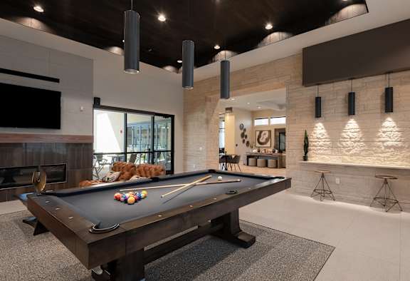 A pool table is in the middle of a room with a fireplace and a TV.