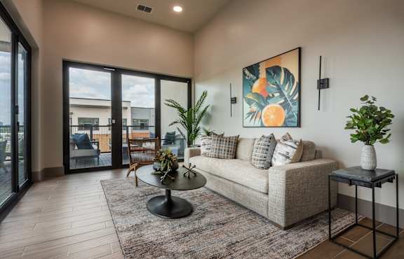 A living room with a couch, a table, and a painting on the wall.