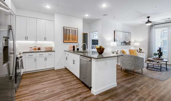 A modern kitchen with white cabinets and a wooden island.