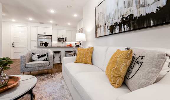 A living room with a white couch and a grey armchair.