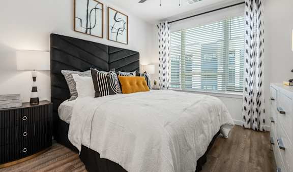 A bedroom with a large bed and a ceiling fan.