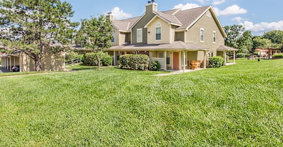 a large house on a hill with a grassy yard at Highland Ridge Apartments, Overland Park , KS 66210