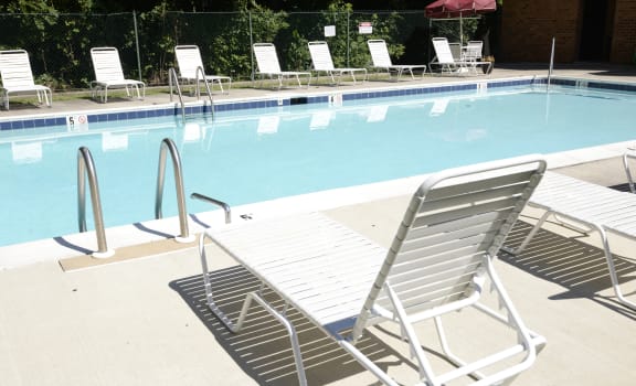 a swimming pool with chaise lounge chairs and a poolside umbrella at Ivy Hall Apartments*, Towson, MD