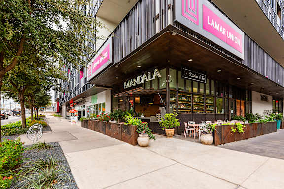 A street view of a Lamar Union store with a wooden facade and outdoor seating area.