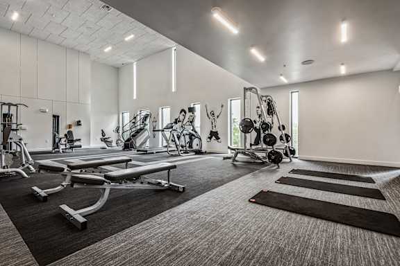 A spacious gym with a variety of equipment including treadmills, weights, and exercise machines.