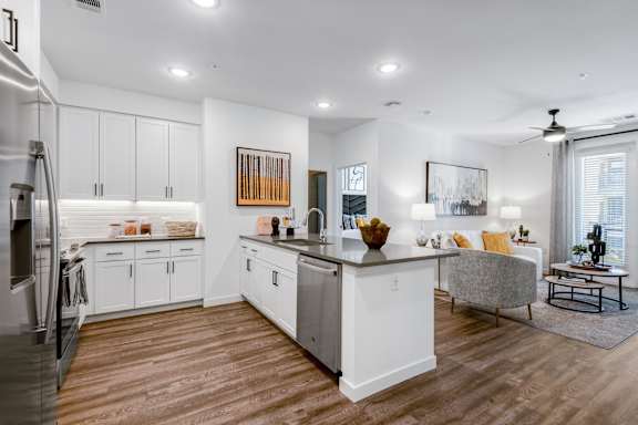 A modern kitchen with white cabinets and a wooden island.