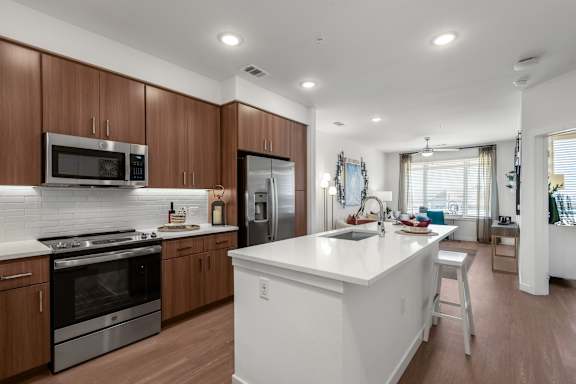 A modern kitchen with wooden cabinets and stainless steel appliances.