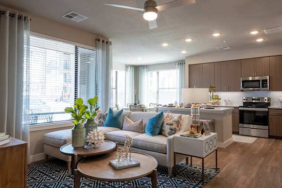 A modern living room with a sofa, coffee table, and kitchen area.
