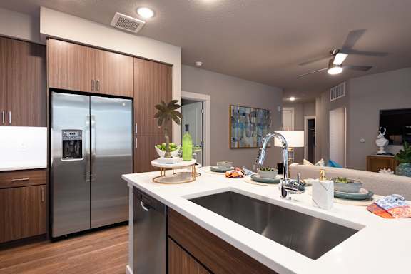 A modern kitchen with a stainless steel refrigerator and wooden cabinets.
