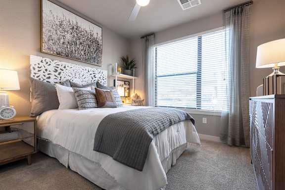 A bedroom with a large bed and a painting above it.