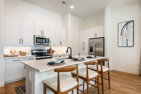 A modern kitchen with white cabinets and a white countertop.
