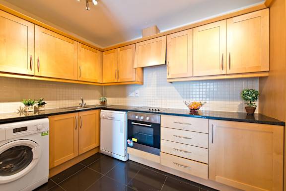 a kitchen with wooden cabinets and white appliances and a washing machine