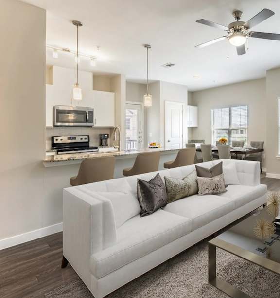 A modern living room with a white sofa and a glass coffee table.