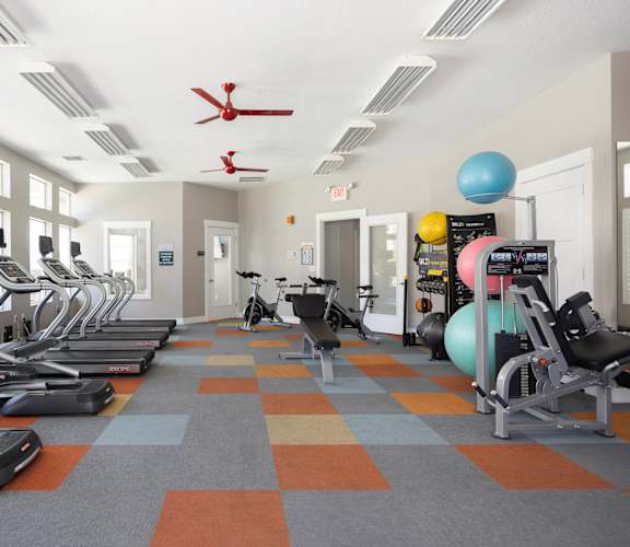 a large fitness room with treadmills and other exercise equipment at The Alloy at Geneva, Vineyard, UT, 84058