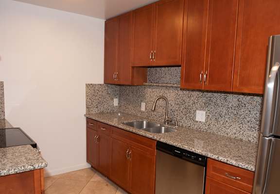 A kitchen with granite countertops and stainless steel appliances.