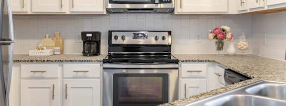A kitchen with a stove, microwave, and refrigerator.