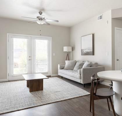 a living room with a couch a table and a ceiling fan at The Alloy at Geneva, Vineyard, 84058