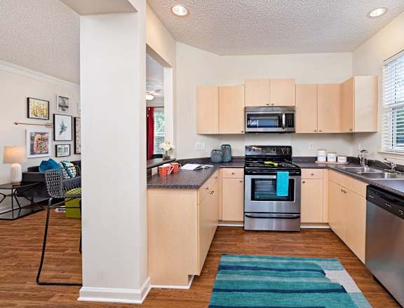a renovated kitchen with stainless steel appliances and wooden floors