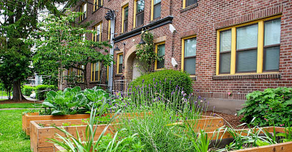 a garden in front of a brick building