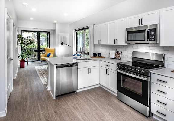 a kitchen with white cabinets and stainless steel appliances