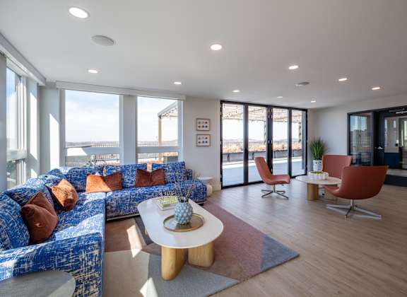 A living room with a blue couch and a white coffee table at Jayde Parkside Apartments, Washington 20019