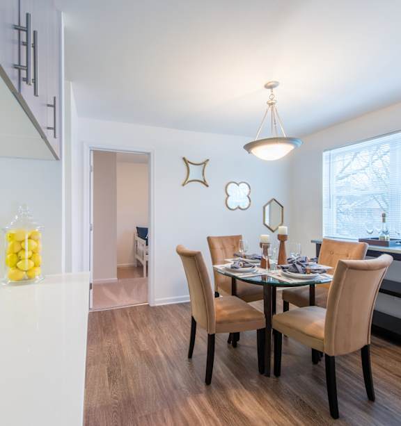 A kitchen with a dining table and chairs.