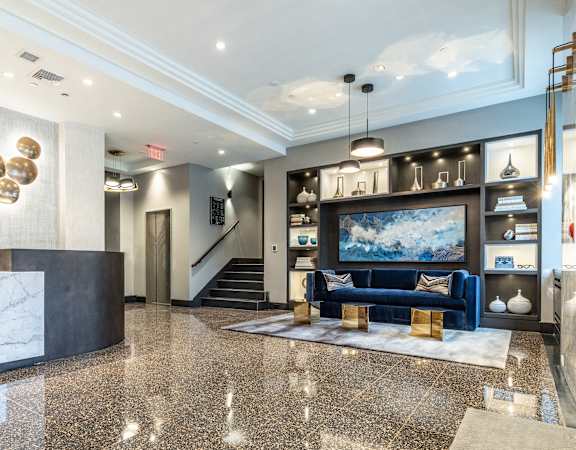 A spacious lobby with a blue sofa and a television set.