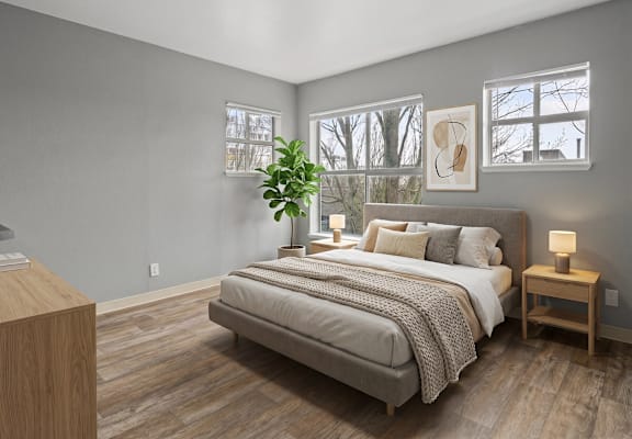 A bedroom with a large bed and a wooden nightstand.