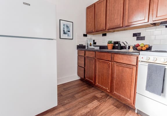 A kitchen with wooden cabinets and a white refrigerator.