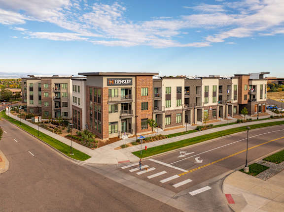 A modern dining room with a long table and chairs.