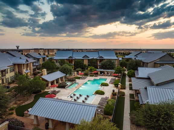 an aerial view of the resort style pool with lounge chairs and umbrellas