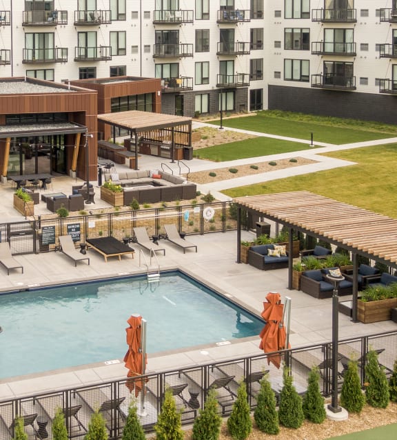 an aerial view of a swimming pool in front of an apartment building