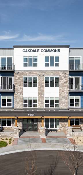 The front of the Oakdale Commons apartment building with a blue sky in the background.