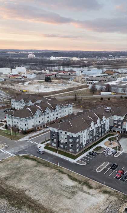 An aerial view of a parking lot and buildings with a cloudy sky.