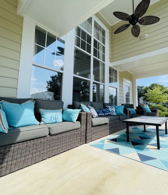 a covered porch with couches and a coffee table at The Chase, Burlington, NC 27215