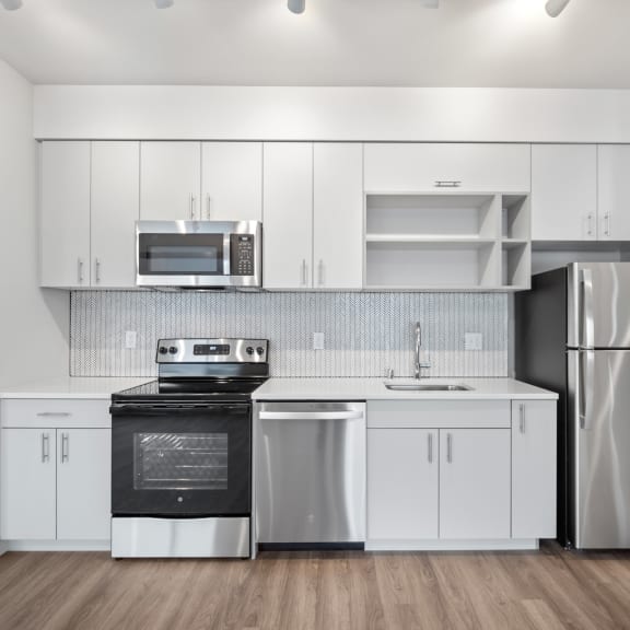 a kitchen with white cabinets and stainless steel appliances