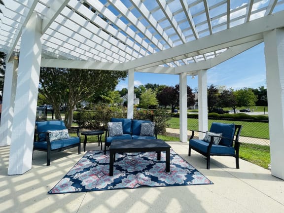 a covered patio with chairs and a table at The Chase, Burlington, NC 27215