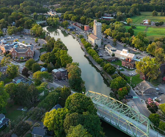 Arial view of the Erie Canal with Schoen Place and the Pittsford Library along either side of the canal and a bridge in the foreground