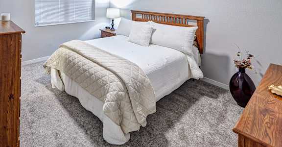 A bedroom with a large bed and a ceiling fan.