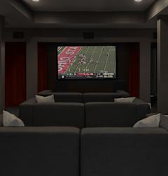 A room with grey couches and a television screen showing a football game.