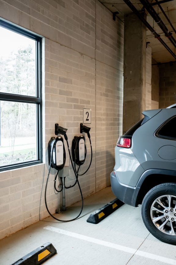 a car is plugged in to an electric charger in a garage