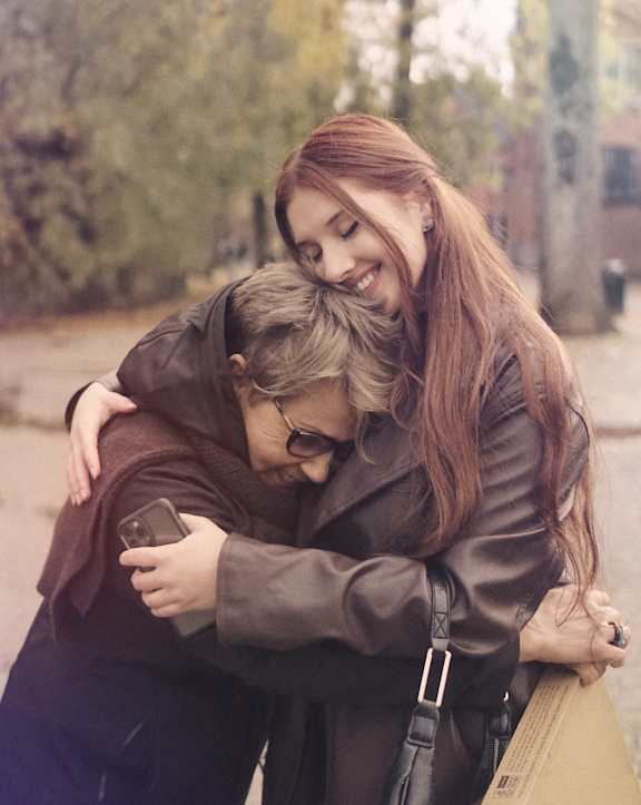 Two people hugging each other in an outdoor setting at Coast Pine