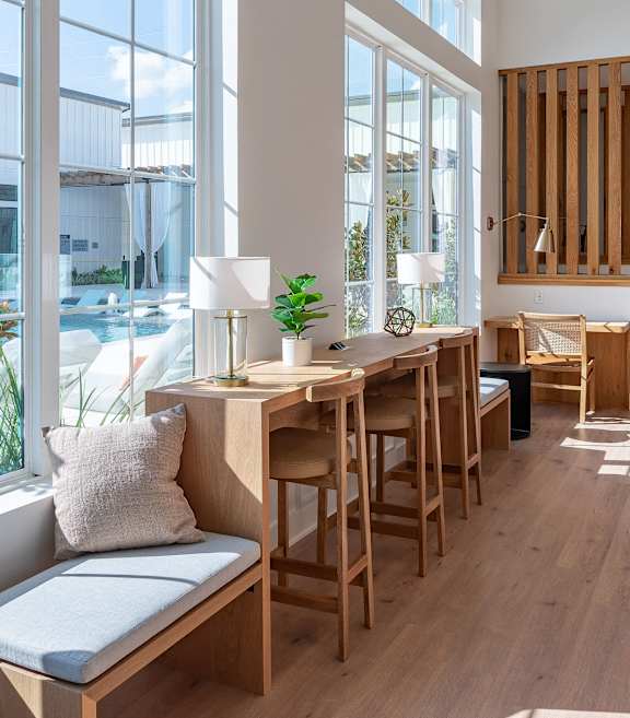 A room with a long table and chairs with a window on the side.