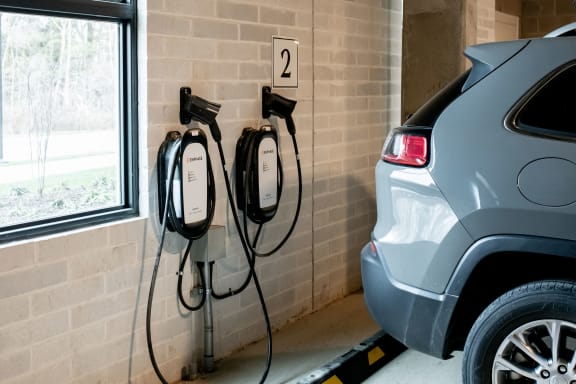a car is plugged in to an electric charger in a garage